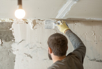 the process of smearing plaster mortar putty with a spatula on the wall close-up.