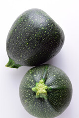 Vertical shot and zenith view, round zucchini on light background.