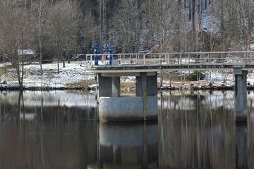 Fototapeta na wymiar overflow barrier dam in winter in falkenstein germany