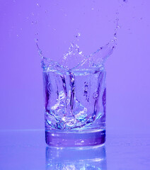 ice cubes falling into glass of water with splash