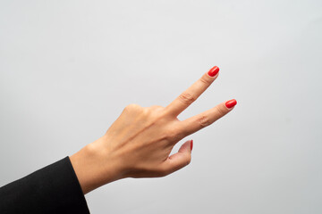 Female hand with red manicure shows gesture on white background