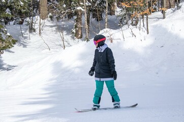 a girl on a snowboard rides down the side of the mountain