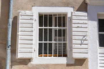 Window with wooden shutters on old stucco wall and copy space