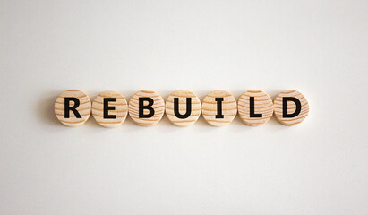 Rebuild and build symbol. The concept word Rebuild on wooden circles. Beautiful white background, copy space. Business rebuild and build concept.