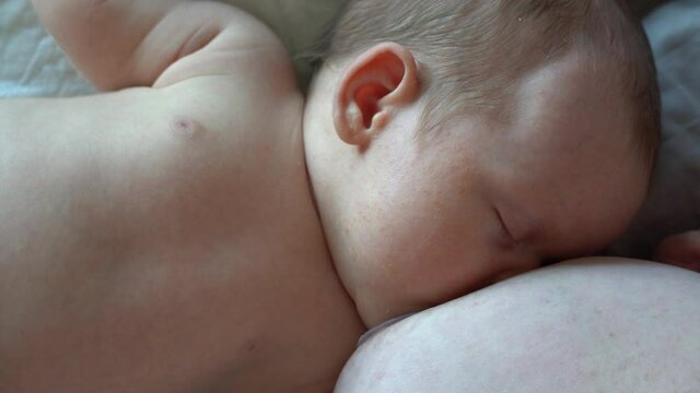 newborn baby eats milk from the mother breast breastfeed through a silicone pad. High quality photo