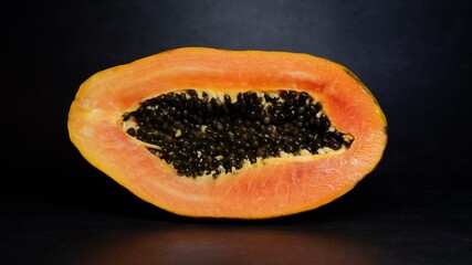 Papaya fruit divided in half as a side cut with seeds