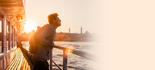 Fototapeta premium A young travelling man on a ferry floats to the shores of Istanbul,