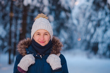Fototapeta na wymiar Happy Asian woman walking in winter snow forest. Cold weather hat and warm coat. idea and concept of healthy active lifestyle and good mood in any weather