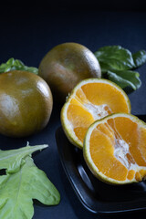 Closeup of a new orange variety, Navel Chocolate orange, from Valencia, Spain against dark background.