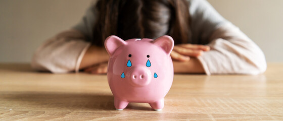 Sad girl with a crying piggy bank.