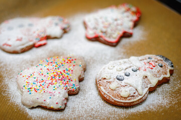 Christmas cookies sprinkled with icing sugar on a baking sheet.