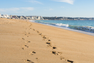 Closeup of footprints on sand by the sea with blurred background on sunny day in Algarrobo beach, Chile