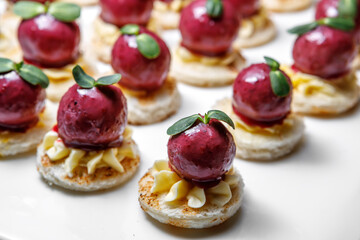 Duck liver rolled into a beetroot ball with buttercream and decorated with herbs.