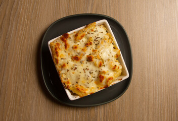 Oven-baked pasta with cheese, olive, Pasta, beef, chicken and vegetables gratin in baking dish