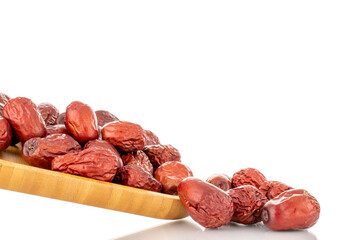 Several slice dried ziziphus berries on a wooden tray, close-up, isolated on white.