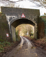 Obraz premium One of the many Bure Valley railway bridges over a rural road in the village of Brampton, Norfolk. With a 4.1m height restriction this bridge is not suitable for high vehicles.