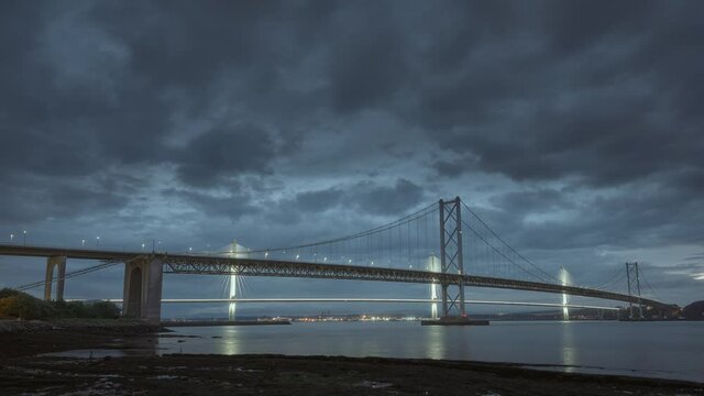 Time-lapse of two bridges and moving clouds at sunset, Forth Road Bridge and Queensferry Crossing, Scotland, United Kingdom