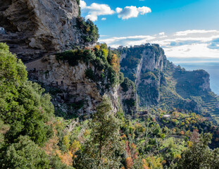 View along the Amalfi Coast of Italy from the Sentiero degli Dei, aka Path of the Gods, during December with autumn leaf color, white limestone cliffs and the turquoise blue Tyrrhenian Sea