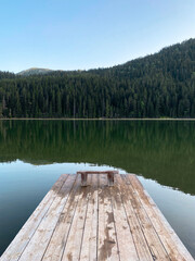 Wooden feast on a mountain lake with a view of the mountains and forest, perspective, beautiful landscape