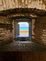 Fort Jefferson, Dry Tortugas National Park, Florida Keys. Looking out from the brick fort. Window with Totten Shutters. Moat wall, or counterscarp, and Gulf of Mexico turquoise water. 