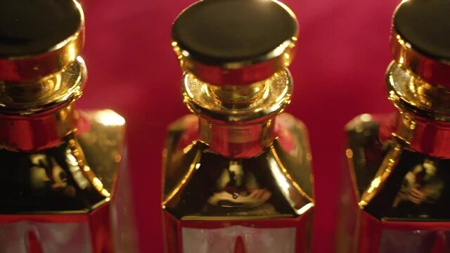Gold glass perfume bottles stand on table with red tablecloth