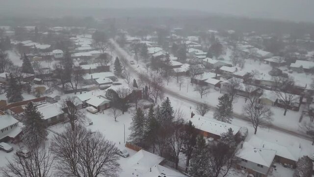 Winter aerial view of snow covered houses in a residential community.