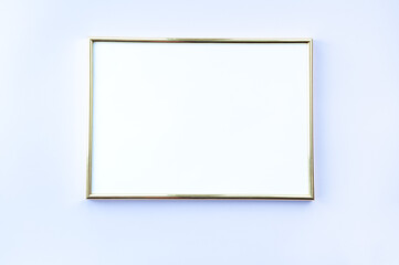Empty frame on gentle purple background. A golden photo fra,e lying on background with place for your text. Mock up.