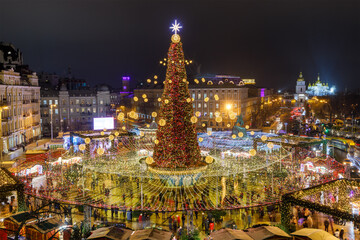 Fototapeta premium Festive square of Sophia in Kyiv, Ukraine. Main Christmas tree of counry in the capital of Ukraine. Nighte view. Michajlivsky temple in background.