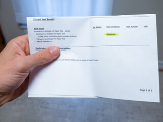 Point of view of a person looking at their positive test results for COVID
