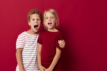 Cute stylish kids smiling and posing in casual clothes against isolated background