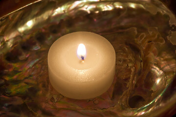 Seashell With Candle. Extreme Close. Abalone seashell with a lit candle. Stock Image.