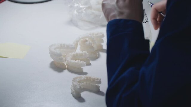production of dentures. A factory employee marks teeth on a 3D printer. dentistry using modern technologies. building industrial capabilities into medicine