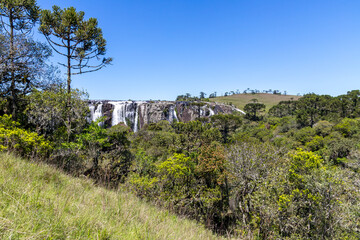 Fototapeta na wymiar Waterfall with fields and forest around