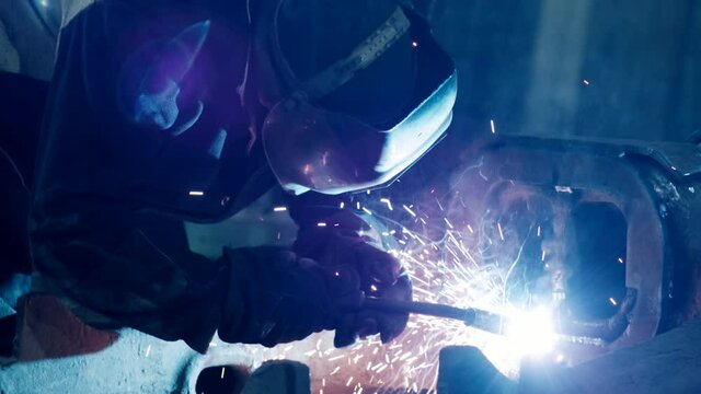 heavy industry, welder welds metal parts for car repair