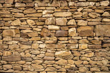Wide Shot of Stacked Stone Wall with beige Rocks
