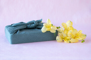 Obraz na płótnie Canvas 風呂敷包みとレモンイエローのアルストロメリアの花束 