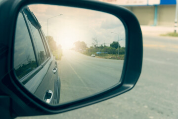 Mirror wing of beside car. Reflection in the mirror empty road traffic on asphalt road.