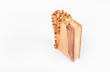 Bible with wooden cross isolated on white background.