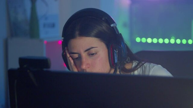 Close up of young gamer woman boring during video game at home