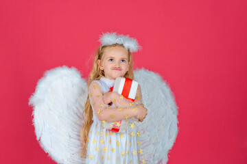 Gift child emotions. Valentine. Little cupid girl. Kid angel with present. Little angel with white wings holds gift on red. Valentine gift card.