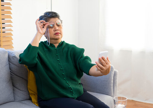 Farsightedness Concept. Elderly Woman Squinting While Looking At Smartphone Screen, Trying To Read Message.