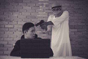 Terrorist using gun threaten hacker for stealing personal data from internet.