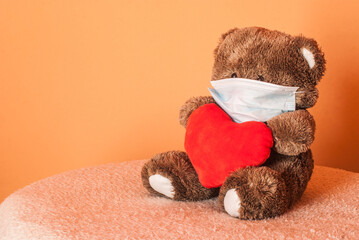 Sick teddy bear wearing a medical face mask. Valentine's day quarantine. 