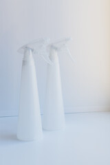 White sprayers for indoor flowers on the windowsill at the window in the house