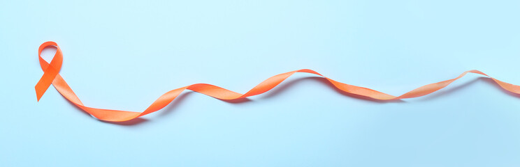 Orange ribbon on color background. Kidney cancer and leukaemia awareness concept