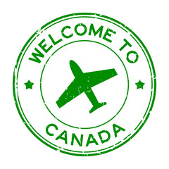 Grunge green welcome to Canada word with airplane icon round rubber seal stamp on white background