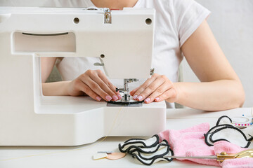 Woman sewing reusable cotton pad at table