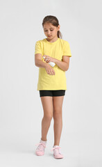 Naklejka premium Little girl with mosquito repellent on light background