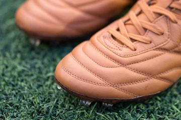 Fotobehang A kangaroo leather football shoe in vintage brown colorway with classic style stitching pattern. Close-up at the upper detail. Sport equipment object photo. © Nattawit
