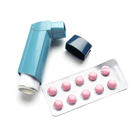 Modern asthma inhaler and blister pack of pills on white background